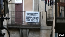 A local in Barcelona makes their feelings felt about the tourism in the capital of Catalonia. (Photo: J. Dettmer/VOA)