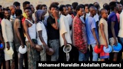 Ethiopian men who fled war in the Tigray region queue for food at the Um-Rakoba camp, on the Sudan-Ethiopia, November 19, 2020.