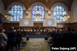 NETHERLANDS -- The delegations of the U.S., front left, and the Islamic Republic of Iran, front right, rise as judges, rear, enter the International Court of Justice, or World Court, in The Hague, October 3, 2018.