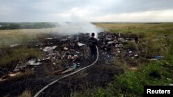 Ukraine -- An Emergencies Ministry member works at putting out a fire at the site of the downed Malaysia Airlines Boeing 777 the settlement of Hrabovo in the Donetsk region, July 17, 2014