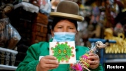 Victoria Acarapi holds a figure of the coronavirus and a llama fetus as part of an offering during the Pachamama (Mother Earth) month at the witches market, amid the outbreak of the coronavirus disease (COVID-19) in La Paz, Bolivia August 1, 2020. 