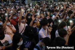 Pro-democracy demonstrators in June 2020 shine flashlights on their mobile phones to mark the one-year anniversary of a mass rally against a controversial extradition bill.