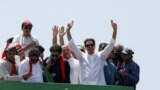 Ousted Pakistani Prime Minister Imran Khan gestures as he travels on a vehicle to lead a protest march to Islamabad, in Mardan, Pakistan, May 25, 2022. (Fayaz Aziz/REUTERS)
