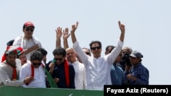 Ousted Pakistani Prime Minister Imran Khan gestures as he travels on a vehicle to lead a protest march to Islamabad, in Mardan, Pakistan, May 25, 2022. (Fayaz Aziz/REUTERS)