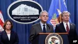 Attorney General Merrick Garland, center, flanked by Deputy Attorney General Lisa Monaco, left, and FBI Director Christopher Wray, announce charges against two men suspected of being Chinese intelligence officers, Monday, October 24, 2022. (J. Scott Applewhite/AP)