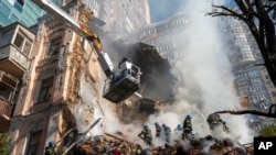 Firefighters work after a Russian drone attack on buildings in Kyiv on October 17, 2022. (Roman Hrytsyna/AP)