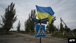 A photograph taken on September 27, 2022, shows a Ukrainian flag waving on a street of the then recently liberated village of Vysokopillya, in the Kherson region. (Genya SAVILO/AFP) 