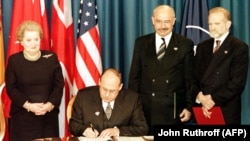 U.S. -- Czech Republic's Foreign Minister Jan Kavan (seated) signs the accession document that enters the Czech Republic into NATO at the Harry Truman library in Independence, March 12, 1999