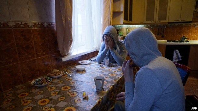 Chechen gay men who fled persecution in their home Russia's Muslim region of Chechnya due to his sexual-orientation, sits around a table in their flat in Moscow on April 17, 2017. / AFP PHOTO / Naira DAVLASHYAN / TO GO WITH AFP STORY BY Anais LLOBET