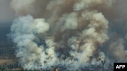 Aerial picture showing smoke billowing from a forest fire in the municipality of Candeias do Jamari in Rondonia State, on August 24, 2019.