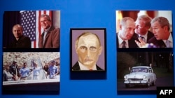 U.S. -- A portrait of Vladimir Putin, President of Russia painted by former president George W. Bush is displayed between photographs as part of the exhibit, "The Art of Leadership: A President's Personal Diplomacy" at the George W. Bush Presidential Libr