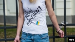 Czech Republic -- A pro-Ukraine activist wearing a t-shirt with Czech writing reading 'no more Munich agreement' is handcuffed to the railings of the Russian Embassy in Prague, February 25, 2015