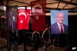 People walk past banners with the photograph of Turkish CHP party leader and Nation Alliance's presidential candidate Kemal Kilicdaroglu in Istanbu on April 18, 2023. (Francisco Seco/AP)