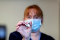 FILE PHOTO: A member of the staff holds the Pfizer/BioNTech COVID-19 vaccine at the Abercorn House Care Home in Hamilton, Scotland, Britain December 14, 2020.