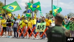 Supporters of President Jair Bolsonaro protest against quarantine and social distancing measures imposed by governors and mayors and demand military intervention (AI-5) in Brasilia, on April 19, 2020.