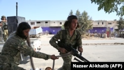 Turkish-backed Syrian fighters take part in a battle in Syria's northeastern town of Ras al-Ain in the Hasakeh province along the Turkish border as Turkey and its allies continue their assault on Kurdish-held border towns in northeastern Syria.