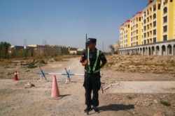 A Chinese police officer takes his position by the road near what is officially called a vocational education center in Yining, Xinjiang Uyghur Autonomous Region, China on September 4, 2018.