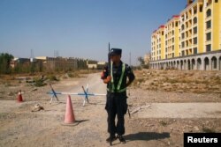 A Chinese police officer takes his position by the road near what is officially called a vocational education center in Yining, Xinjiang Uyghur Autonomous Region, China on September 4, 2018.