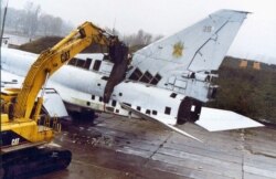 A machine equipped with a large cutting device severs a Tu-22 strategic bomber at a military airfield in the city of Poltava, Ukraine, November 12, 2002.