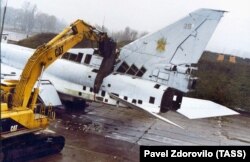 A machine equipped with a large cutting device severs a Tu-22 strategic bomber at a military airfield in the city of Poltava, Ukraine, November 12, 2002.