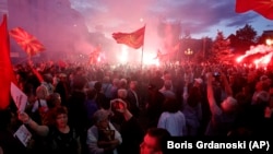 MACEDONIA -- Opponents of the deal between Greece and Macedonia on the latter country's new name "North Macedonia" light flares while protesting outside the parliament in Skopje, Macedonia, Saturday, June 23, 2018.