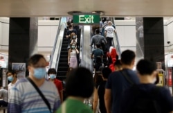 Commuters wearing protective face masks leave a train station during the coronavirus disease (COVID-19) outbreak in Singapore August 17, 2020.