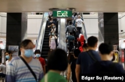 Commuters wearing protective face masks leave a train station during the coronavirus disease (COVID-19) outbreak in Singapore August 17, 2020.