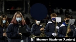 Members of the Kirtland Hornets band wear face masks at the Ohio high school football playoffs.