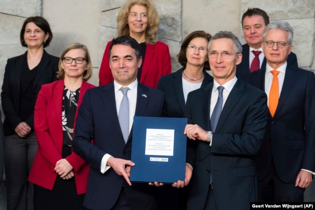 BELGIUM -- NATO Secretary-General Jens Stoltenberg, 3rd right, and Macedonian Foreign Minister Nikola Dimitrov, 3rd left, pose for photographers together with NATO permanent representatives after they signed the "accession protocol" in a ceremony at NATO