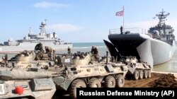 UKRAINE -- Russian military's armored vehicles roll into landing vessels after drills in Crimea, April 23, 2021. (Russian Defense Ministry/AP)