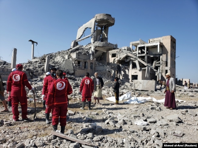 Yemen-- Red Crescent medics stand at the site of Saudi-led air strikes on a Houthi detention centre in Dhamar, September 1, 2019