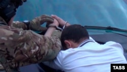 An FSB officer arrests a suspected member of the Islamic State group in Russia. 