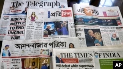 Indian vernacular and English newspapers carry headlines of U.S. President Joe Biden's inauguration in Kolkata on January 21, 2021. Bikas Das/AP