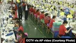 CHINA – In this file image from undated video footage run by China's CCTV, Muslim trainees work in a garment factory at the Hotan Vocational Education and Training Center in Hotan, Xinjiang.