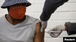 A volunteer receives an injection from a medical worker during the country's first human clinical trial for a potential vaccine against the novel coronavirus, at Baragwanath Hospital in Soweto, South Africa, June 24, 2020. REUTERS/Siphiwe Sibeko