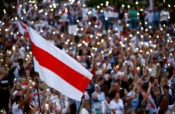 Minsk, Belarus - A historical white-red-white flag of Belarus is seen as people attend an opposition demonstration to protest against presidential election results