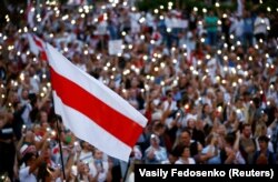 Minsk, Belarus - A historical white-red-white flag of Belarus is seen as people attend an opposition demonstration to protest against presidential election results