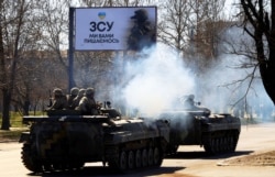Ukrainian servicemen on armored vehicles in the city of Mykolaiv on March 28, 2022. (Nacho Doce/Reuters)