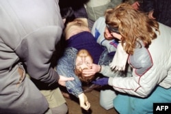 Lithuania -- A dead Lithuanian pro-independence supporter has his eye opened by one of his comrades before being taken away in Vilnuis, January 13, 1991