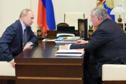 RUSSIA -- Russian CEO of Rosneft oil company Igor Sechin, right, speaks to Russian President Vladimir Putin during a meeting at the Novo-Ogaryovo residence outside Moscow, August 18, 2020.