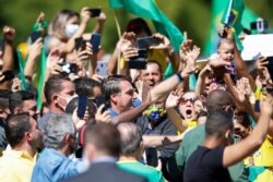 Brazil's President Jair Bolsonaro reacts during a meeting with supporters protesting in his favor, amid the coronavirus disease (COVID-19) outbreak