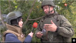 Oleg Nitkin, official representative of the Donestk People’s Militia, showing a reporter from the Russian Defense Ministry's TV Zvezda the remnant from a mortar shell allegedly used by Ukrainian forces in the country's east.
