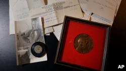 A capsule of original penicillin mold, seen bottom left among other letters and medals, from which Alexander Fleming made the drug known as penicillin on view at Bonham's auction house in London. Feb. 16, 2017 (AP Photo/Alastair Grant)