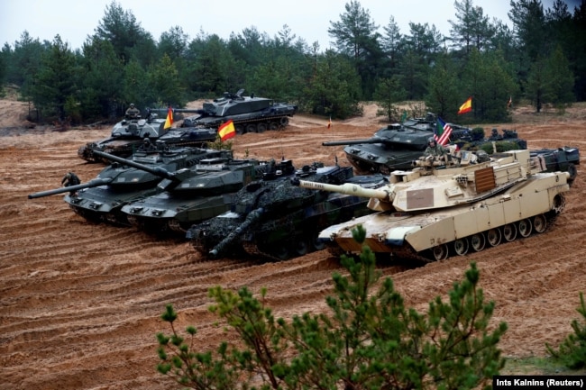 Latvia October - U.S., German, Spanish and Polish troops of the NATO enhanced Forward Presence battle goups with their tanks get ready for the Iron Tomahawk exercise in Adazi