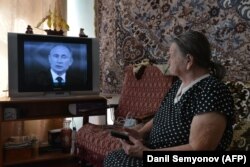 Russia -- An elderly woman watches TV broadcasting of Russian President Vladimir Putin's annual televised question-and-answer session with the nation in the southern city of Stavropol, April 17, 2018