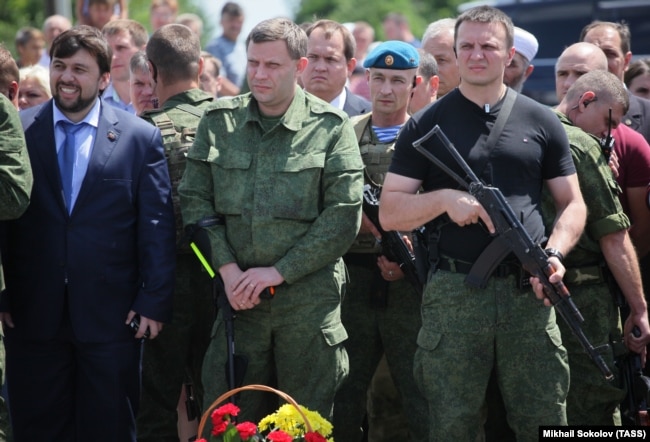 UKRAINE – Alexander Zakharchenko (C), head of the Donetsk People's Republic (DPR), and Denis Pushilin (L), representative of “DPR”, attends the commemorative events in memory of the people, who died during the Malaysia Airlines Boeing 777 crash on 17 July