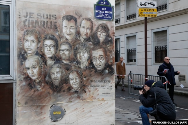 The artwork of French street artist Christian Guemy aka "C215" depicting members of satirical magazine Charlie Hebdo is painted on a facade near the magazine's offices at Rue Nicolas Appert, on Jan. 7, 2020 in Paris.