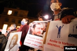 Human rights activists stage a protest over human rights violations in Egypt during an official visit of Egyptian President Abdel-Fattah el-Sissi in Paris, France December 8, 2020.