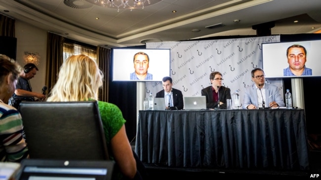 NETHERLANDS -- Eliot Higgins (center), founder of online investigation group Bellingcat, addresses a press conference on findings in research on Malaysia Airlines flight MH17 in Scheveningen, May 25, 2018