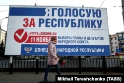 UKRAINE -- A woman walks past an election campaign billboard for elections in areas of eastern Ukraine held by Russia-backed separatists, on a street in Donetsk, November 7, 2018.